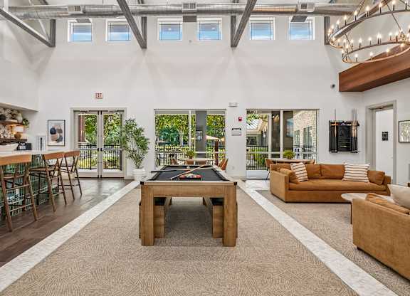 A spacious living room with a pool table in the center.