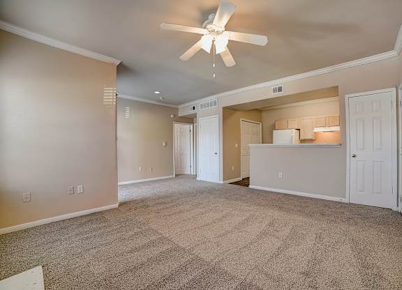 Open living room leading to kitchen pass-through and entry hallway storage.