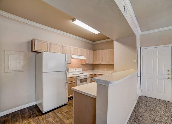 Classic kitchen with light wood cabinetry, white appliances, and raised breakfast bar.