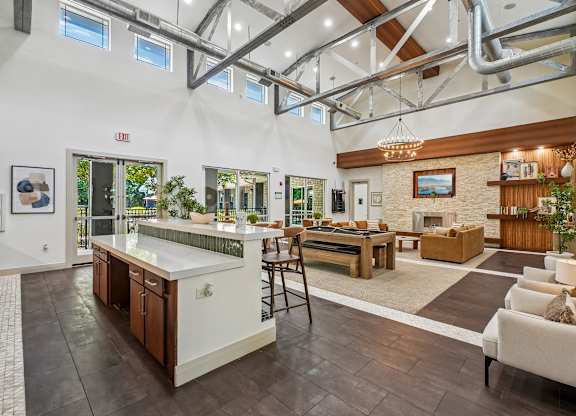 A modern kitchen with a bar area and a living room area.