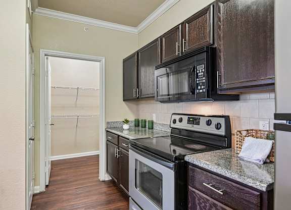 A kitchen with a black microwave above the stove.