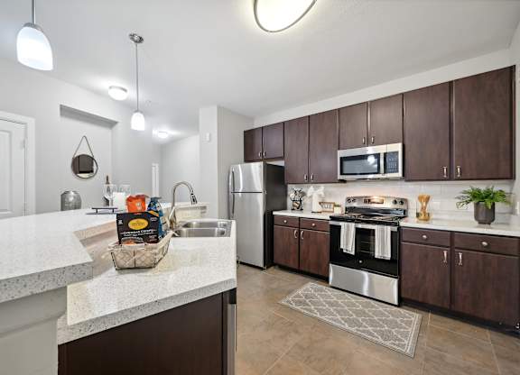 A kitchen with brown cabinets and a white counter.