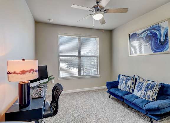 a living room with a blue couch and a ceiling fan