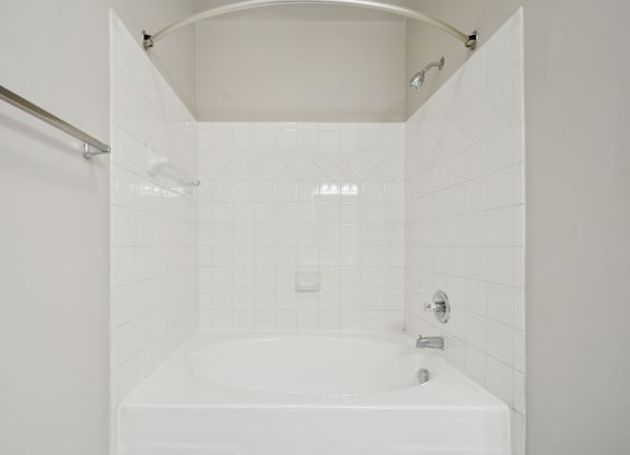 A white bathroom with a tub and shower.