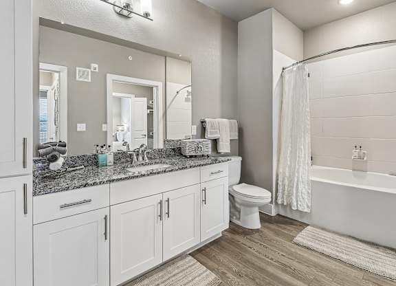 A bathroom with a white toilet, sink, and bathtub.
