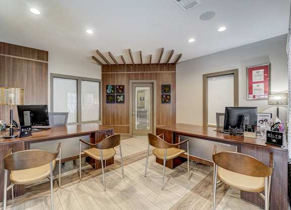 a home office with desks and chairs and a computer