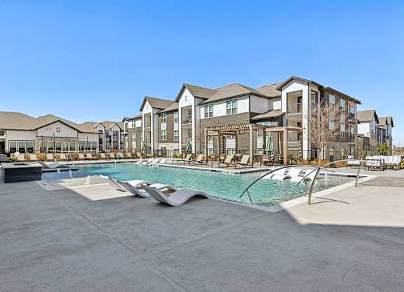 A large swimming pool in front of apartment buildings.
