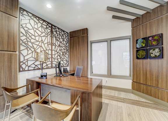 a home office with a wooden desk and two chairs