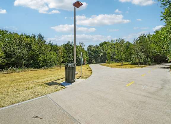 A street with a yellow line on the side and a pole with a red top.