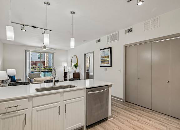 A kitchen with a sink, cabinets, and a window.