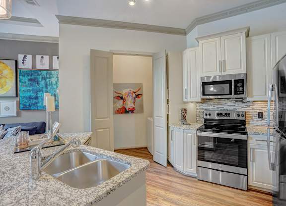 a kitchen with granite counter tops and stainless steel appliances