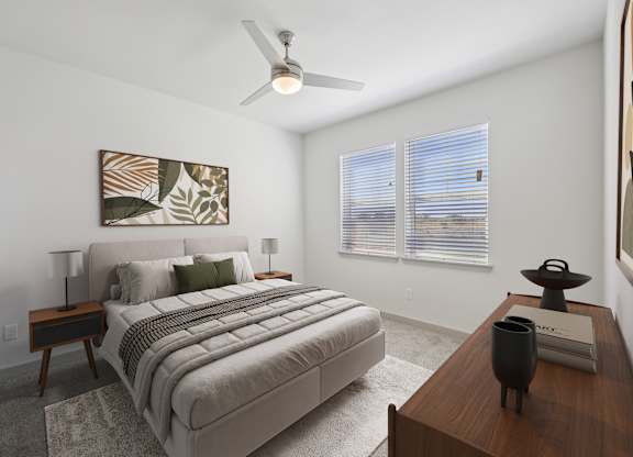 A bedroom with a large bed and a ceiling fan.