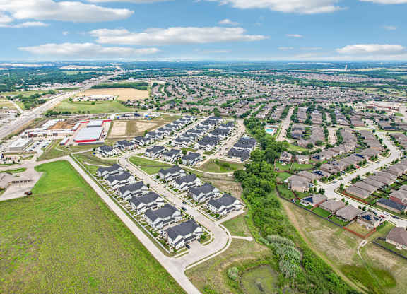 A bird's eye view of a residential area with houses and greenery.