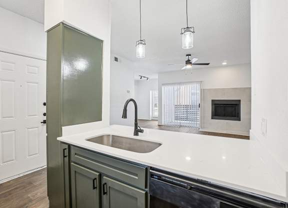 A kitchen with a sink and a green cabinet.
