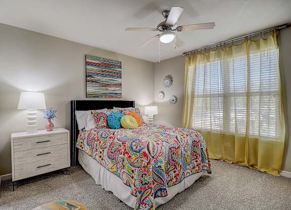 a bedroom with a bed and a ceiling fan