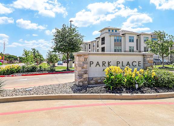 The image shows a sign that says "PARK PLACE" in front of a building.