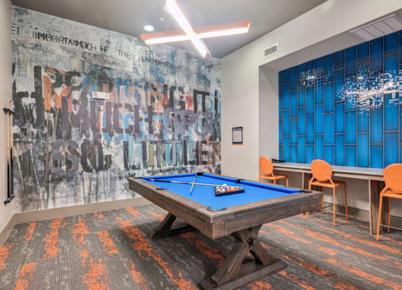 A pool table in a room with a graffiti wall.