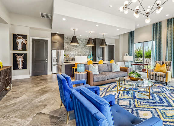 A living room with a blue rug and a grey couch.