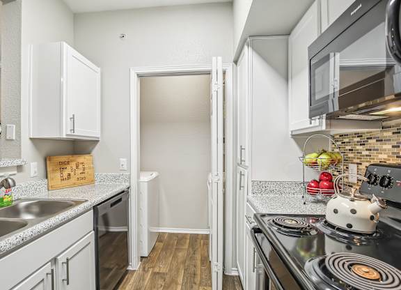 A kitchen with a black stove top oven and a white fridge.