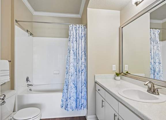 A white bathroom with a blue shower curtain.