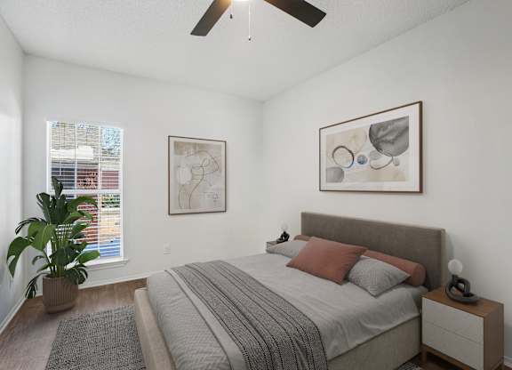A bedroom with a bed, nightstand, and two framed pictures on the wall.