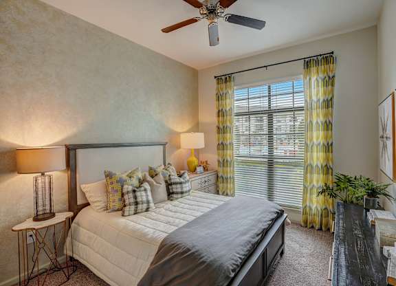 a bedroom with a large bed and a ceiling fan