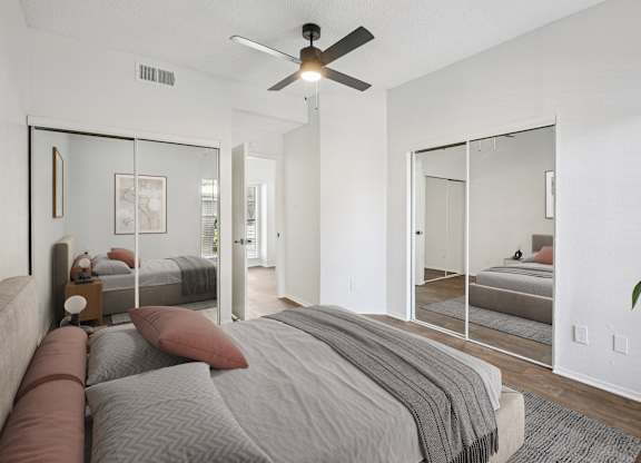 A bedroom with a large bed and a ceiling fan.