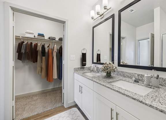 A bathroom with a white vanity and a mirror above it.