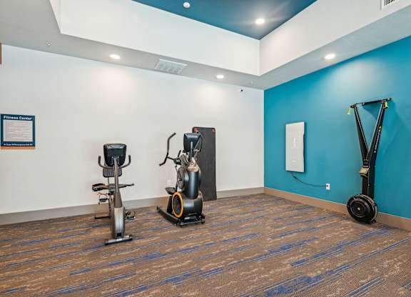 A gym with a blue wall and a wooden floor.