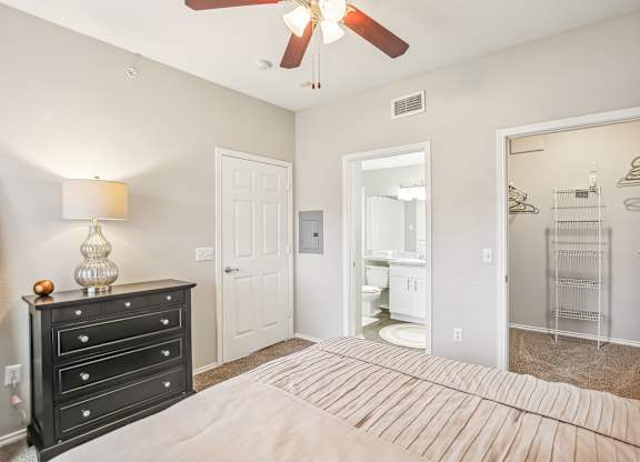 A bedroom with a bed, dresser, and mirror.
