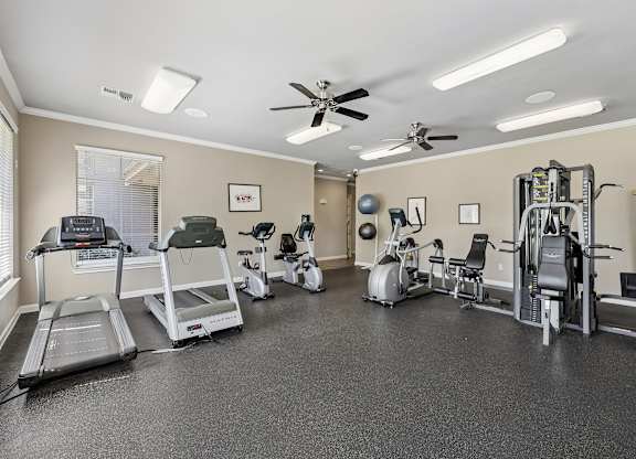 A spacious gym with treadmills, exercise bikes, and other equipment.