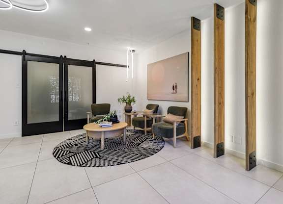 A modern living room with a glass door, a wooden table, and a rug.