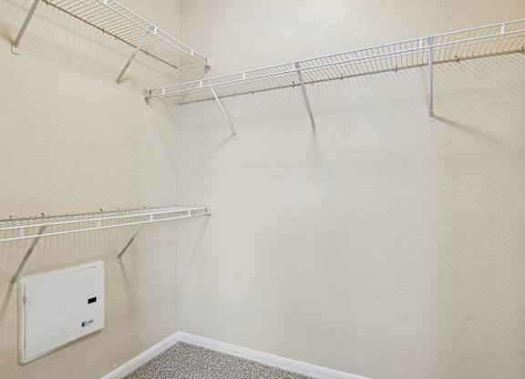 A walk-in closet with a white door and shelves.