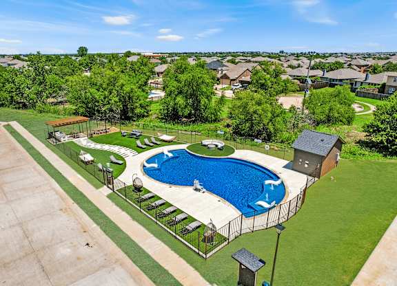 A pool surrounded by a fence and a small building.