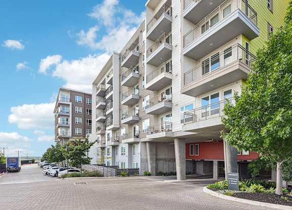 A large apartment building with a parking lot in front.