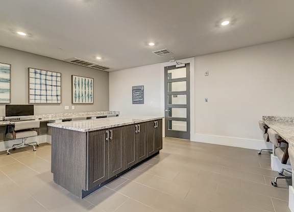 A kitchen with a marble countertop and a long island.