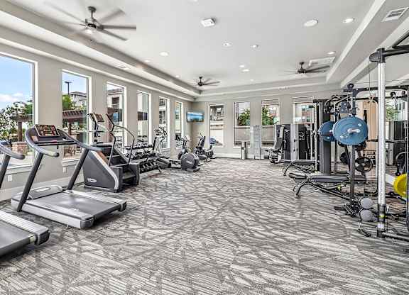 A spacious gym with treadmills, elliptical machines, and other exercise equipment.