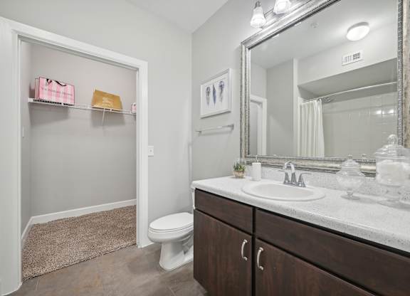 A bathroom with a white toilet, a sink, and a mirror.