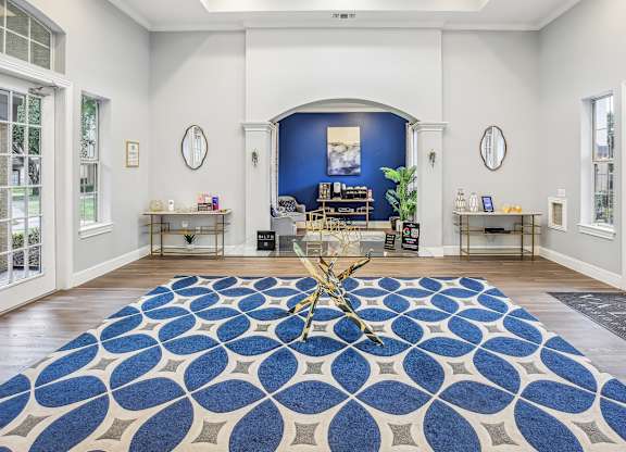 A room with a blue and white patterned rug in the center.