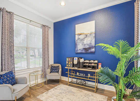 A living room with a blue wall and a painting of water.