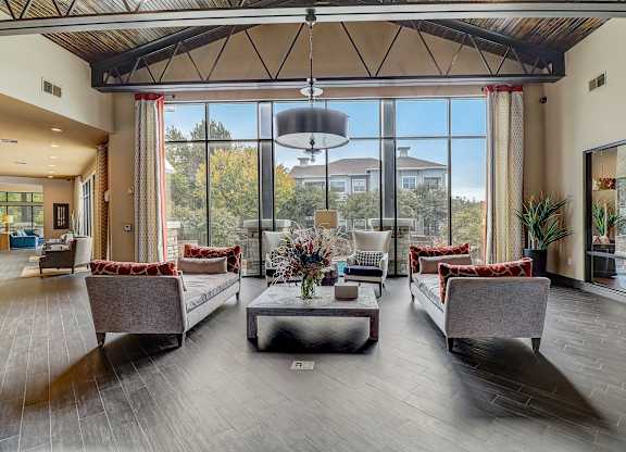 a large living room with couches and chairs and large windows