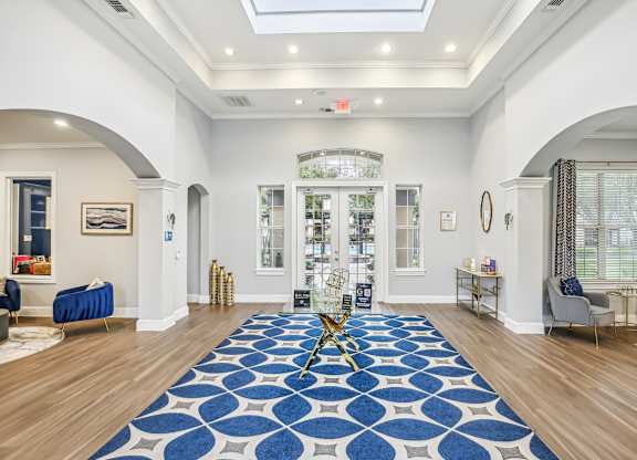 A large blue and white rug is on the floor of a spacious room.