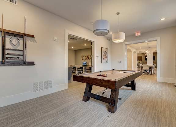 A room with a pool table and a mirror on the wall.