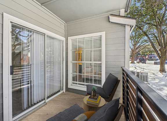 A balcony with a table and chairs is shown.