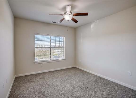 Bright bedroom with large window, ceiling fan, and neutral walls.