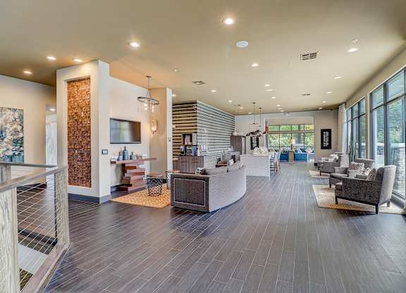 a large lobby with couches and chairs and a television