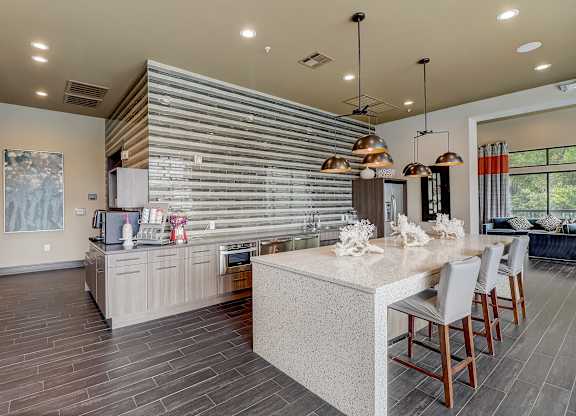 a kitchen with a large island and a table with chairs