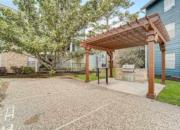 a patio with a pergola in front of a house