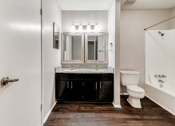 A bathroom with a white toilet and a white bathtub.