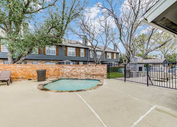 A backyard with a pool and a fence.